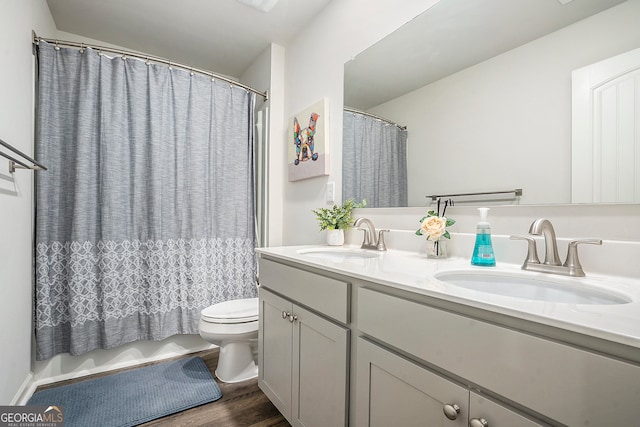 bathroom with curtained shower, vanity, toilet, and hardwood / wood-style flooring