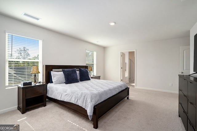 carpeted bedroom featuring ensuite bath