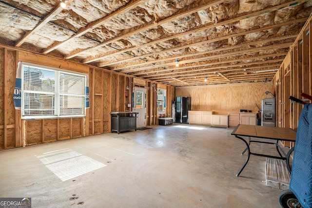 basement with plenty of natural light and black refrigerator