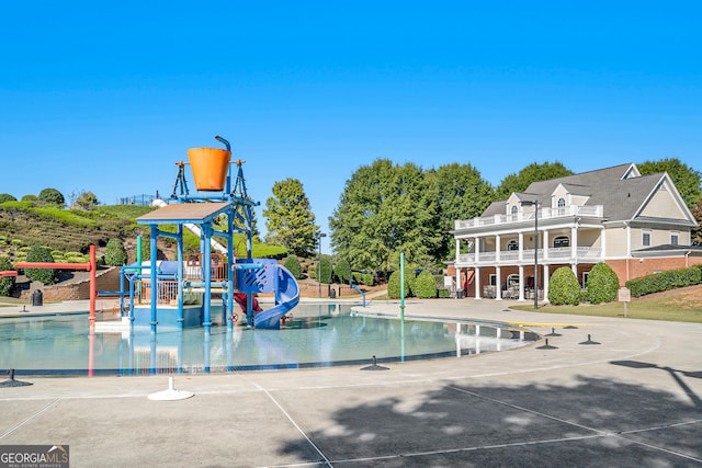 view of pool featuring a playground, a patio, and a water slide