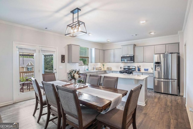 dining space featuring ornamental molding and dark hardwood / wood-style flooring