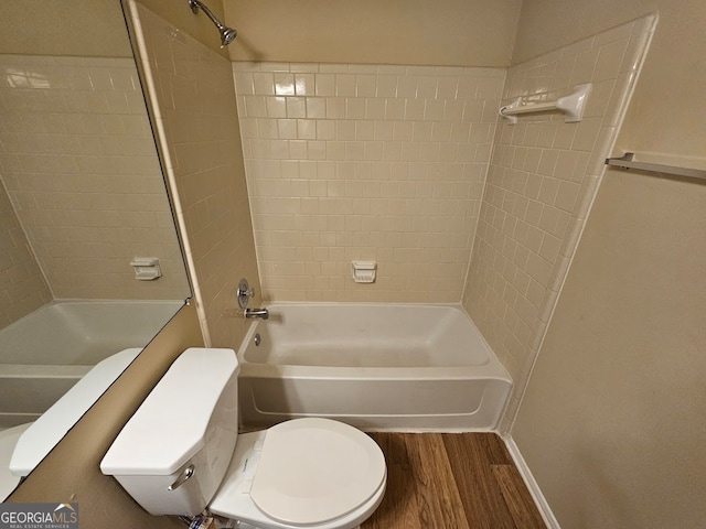 bathroom featuring wood-type flooring, tiled shower / bath combo, and toilet