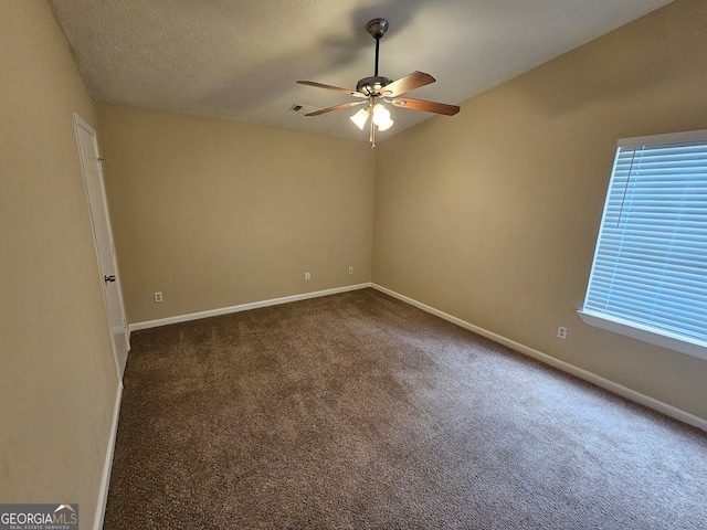 carpeted spare room featuring ceiling fan and a textured ceiling