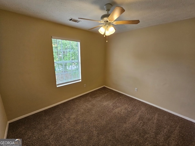 carpeted empty room with ceiling fan and a textured ceiling