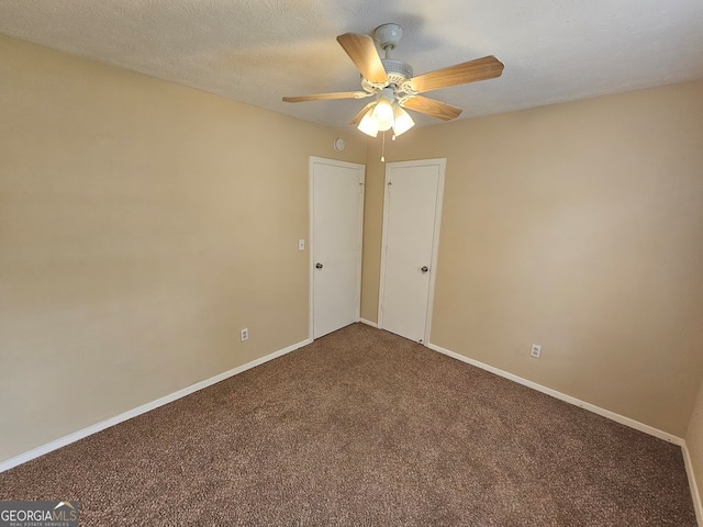 carpeted spare room featuring a textured ceiling and ceiling fan