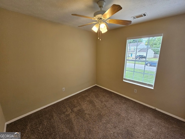 carpeted spare room featuring a textured ceiling and ceiling fan