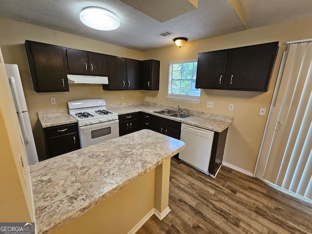 kitchen with wood-type flooring, a textured ceiling, sink, and white appliances