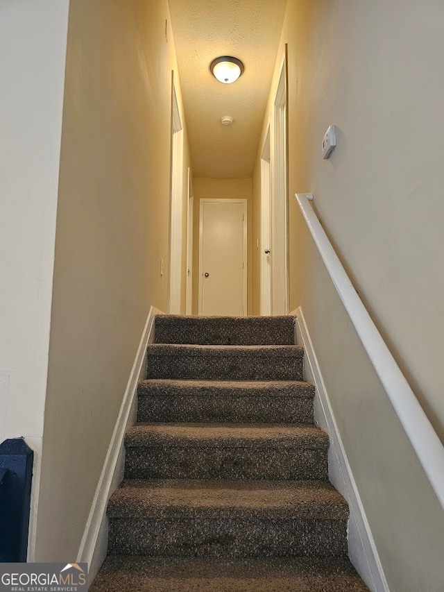 stairway with a textured ceiling