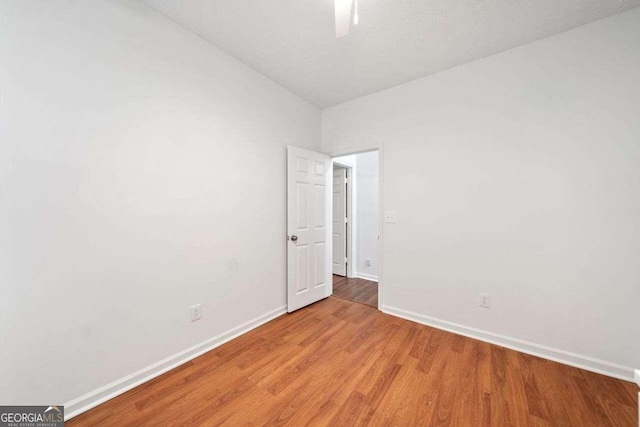 unfurnished room with light wood-type flooring and a textured ceiling