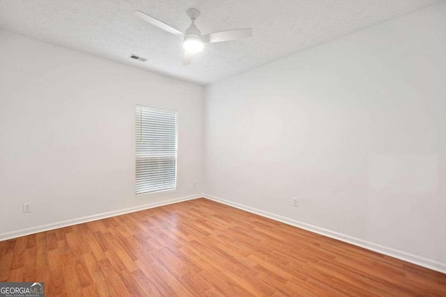 spare room featuring ceiling fan, a textured ceiling, and light hardwood / wood-style floors