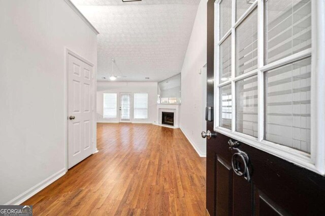 interior space with a textured ceiling and hardwood / wood-style floors