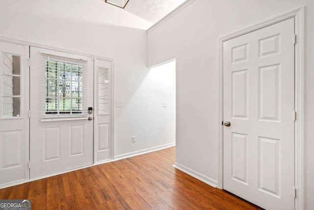 entryway featuring lofted ceiling and hardwood / wood-style flooring