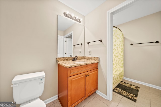 bathroom with toilet, vanity, and tile patterned floors