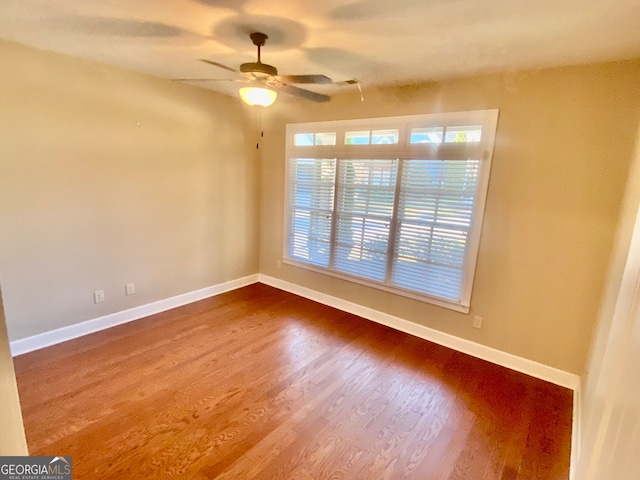 empty room with hardwood / wood-style floors, ceiling fan, and a healthy amount of sunlight