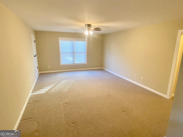 carpeted spare room featuring ceiling fan