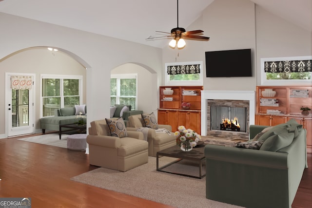 living room with dark hardwood / wood-style flooring, high vaulted ceiling, and ceiling fan