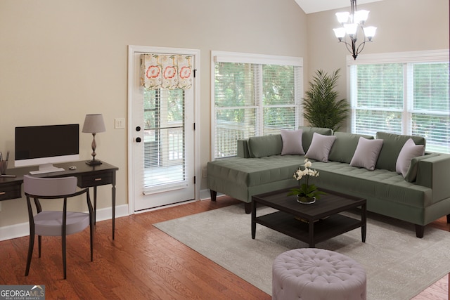 living room with lofted ceiling, light hardwood / wood-style flooring, and a notable chandelier