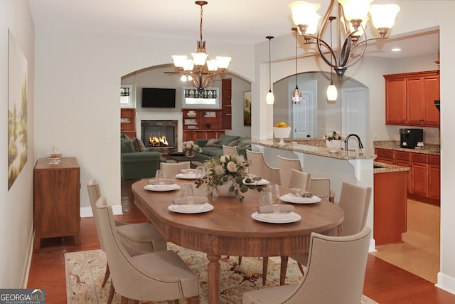 dining space with dark hardwood / wood-style floors, sink, and a chandelier