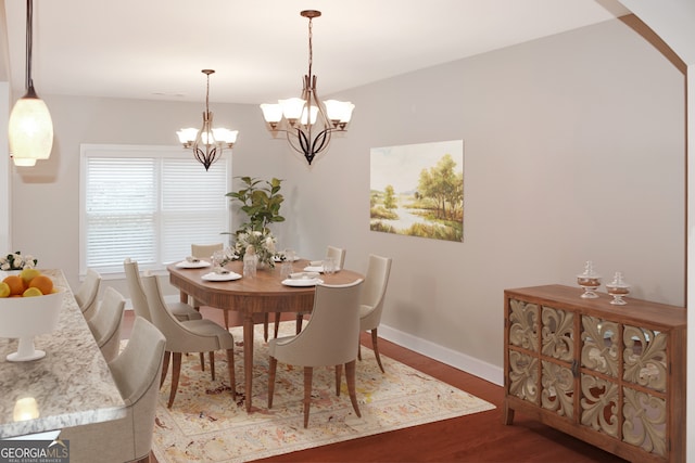 dining area with hardwood / wood-style floors and a chandelier