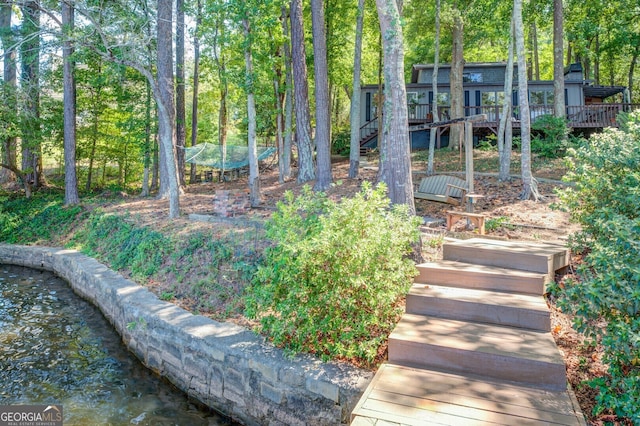 view of yard with a deck with water view