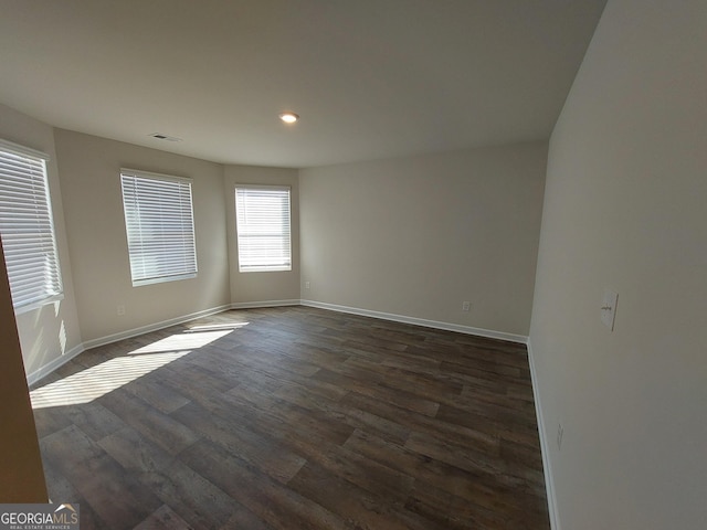 empty room with dark hardwood / wood-style flooring