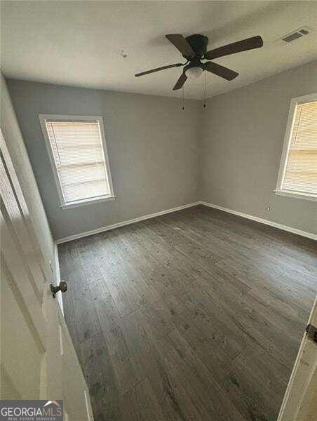 unfurnished room with ceiling fan and dark hardwood / wood-style floors