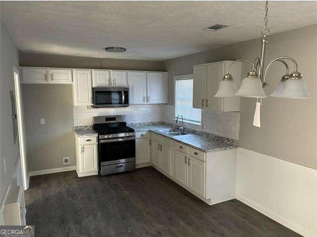 kitchen featuring appliances with stainless steel finishes, sink, dark hardwood / wood-style flooring, and white cabinets