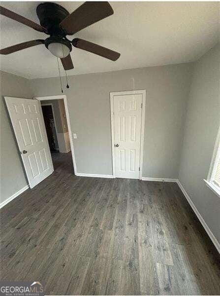 unfurnished bedroom featuring dark hardwood / wood-style floors and ceiling fan