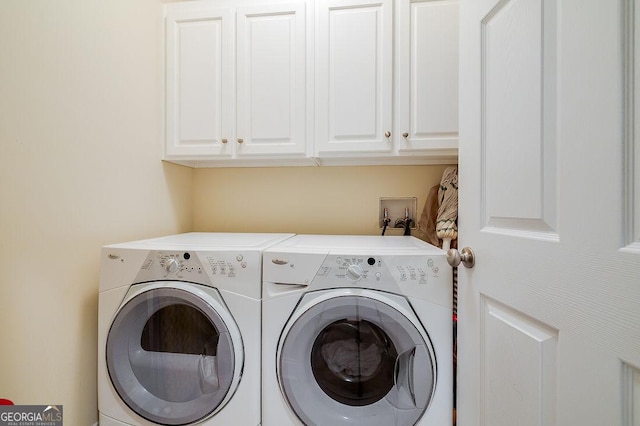 laundry room featuring cabinets and washing machine and clothes dryer