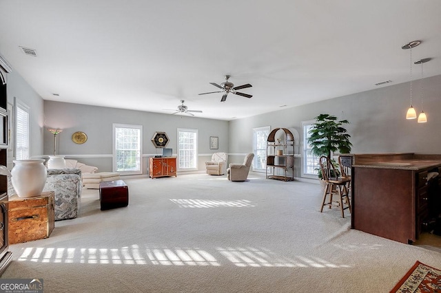 carpeted living room featuring ceiling fan and plenty of natural light