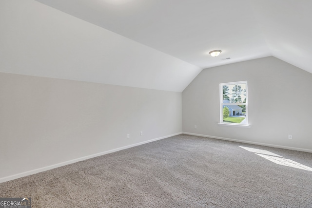 additional living space featuring vaulted ceiling and carpet floors