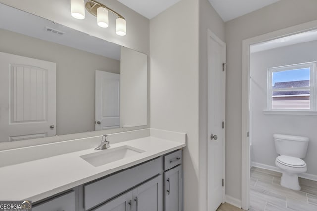 bathroom with vanity, toilet, and hardwood / wood-style flooring