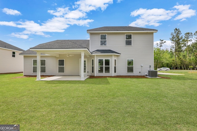 rear view of house with central AC unit, a lawn, and a patio