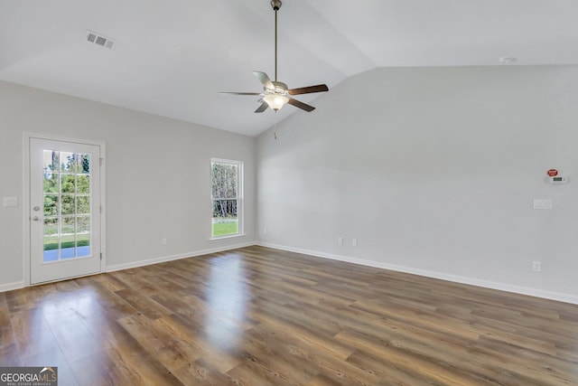 empty room with ceiling fan, dark hardwood / wood-style floors, and vaulted ceiling