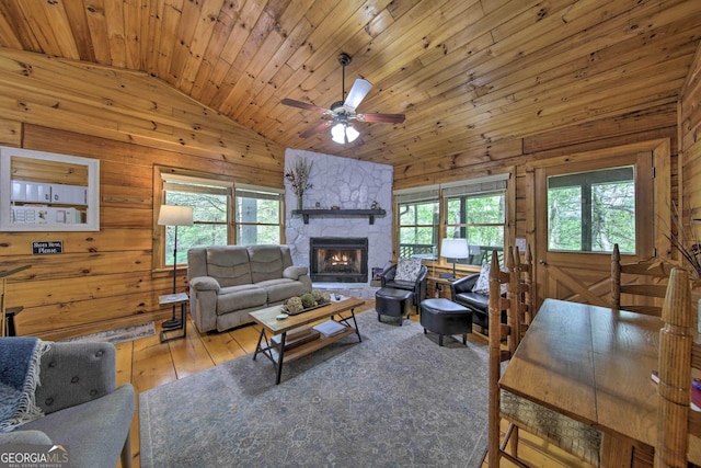 living area featuring lofted ceiling, wood walls, and a wealth of natural light