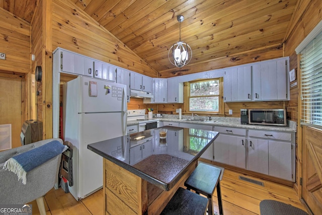 kitchen with under cabinet range hood, white appliances, a sink, light wood-style floors, and vaulted ceiling