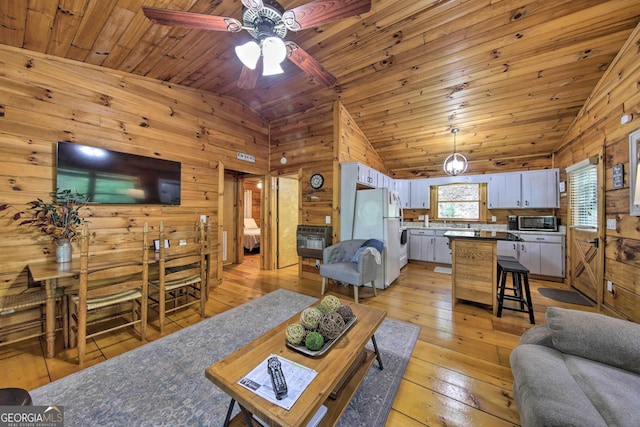 488 Joann Sisson Rd, Blue Ridge, GA 30513 - living room with heating unit, lofted ceiling, wood walls, a ceiling fan, and light wood-style flooring