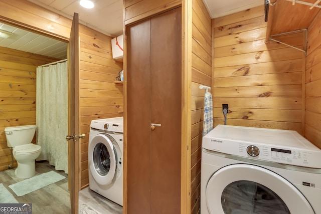 washroom featuring laundry area, wooden walls, and washer / clothes dryer