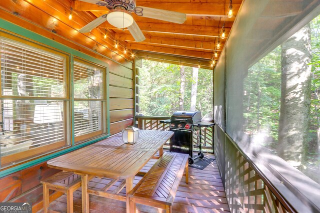 sunroom with beamed ceiling and ceiling fan