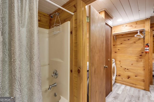 full bathroom with shower / bath combo, wood ceiling, wooden walls, wood finished floors, and washer / dryer