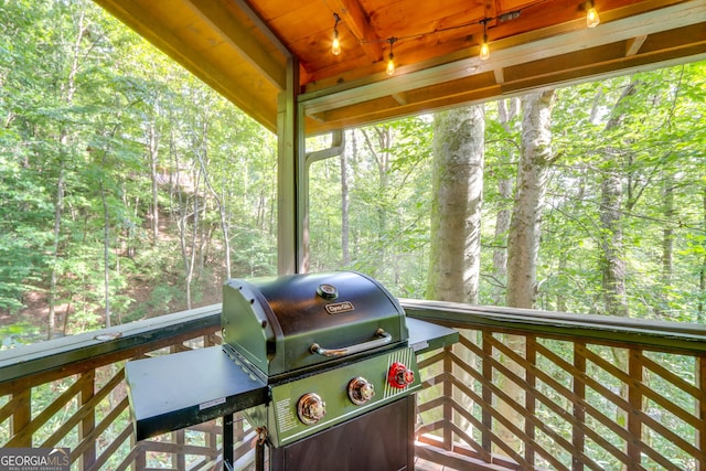 wooden deck featuring a forest view and area for grilling