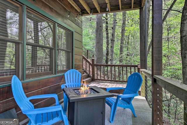 exterior space with a fire pit and a view of trees