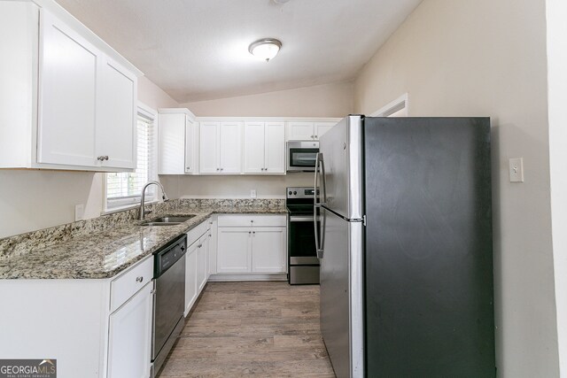 1278 Lynwyn Ln SE, Atlanta, GA 30316 - kitchen with white cabinetry, vaulted ceiling, appliances with stainless steel finishes, and a sink