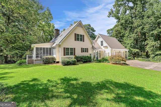 view of property featuring a sunroom and a front yard