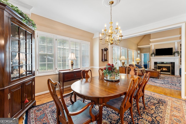 dining area featuring a chandelier, light hardwood / wood-style floors, and crown molding