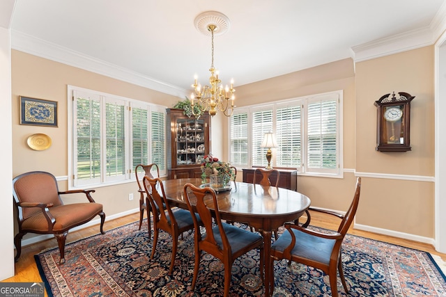 dining room with an inviting chandelier, plenty of natural light, and crown molding