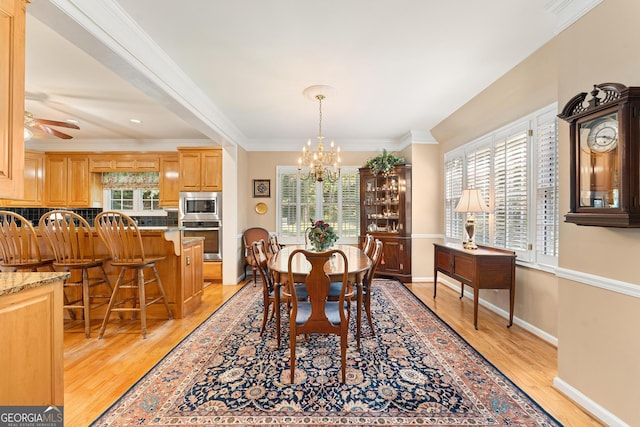 dining area with ceiling fan with notable chandelier, light wood-type flooring, and plenty of natural light