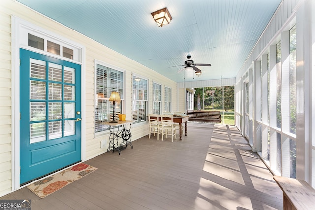 sunroom featuring ceiling fan and plenty of natural light