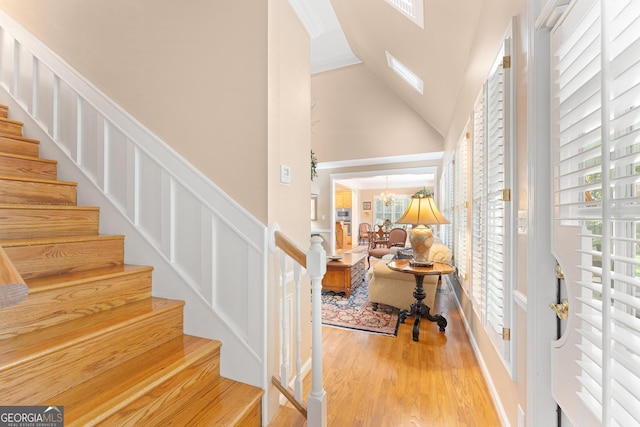 entryway with hardwood / wood-style floors and high vaulted ceiling