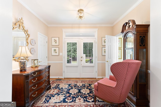 sitting room with hardwood / wood-style flooring and crown molding